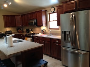 Enjoy cooking in this well-equipped kitchen with a sink, stove, and refrigerator.