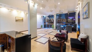Un moderno vestíbulo de hotel con mostrador de recepción, zona de estar y vistas a la ciudad.
