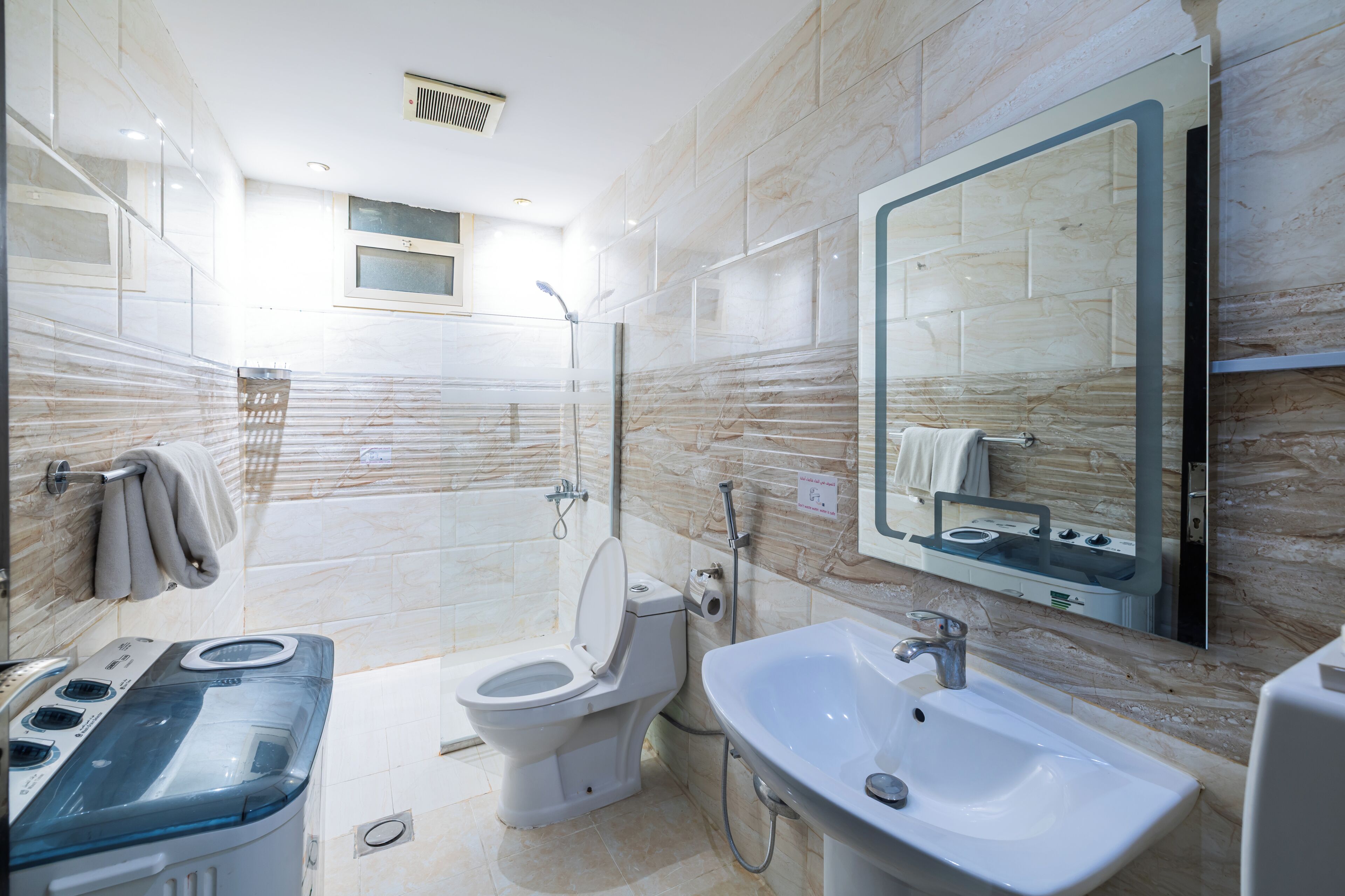 A modern bathroom with a toilet, sink, and shower.