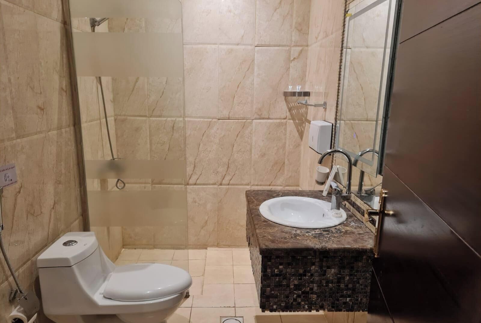 Un baño con inodoro, lavamanos y ducha.