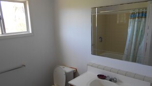 Un bany amb vàter, rentapel i finestra.