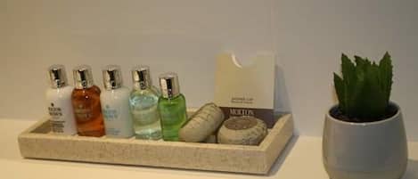 A tray with toiletries and a potted plant on a bathroom counter.