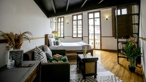 A room with a bed, a sofa, a small table, and a potted plant. - 103 - Bed and Brews (Bangkok)