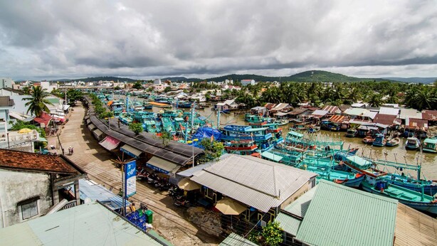 A coastal town with a marina filled with boats, a train station, and a mix of residential and commercial buildings. - Kim Hong Anh Guesthouse (Phu Quoc)