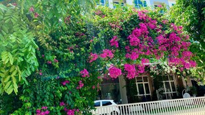A building with a sign reading "HAITIEN PLAZA HOTEL" and a white car parked in front. - Hai Tien Plaza Hotel (Hoang Tien)