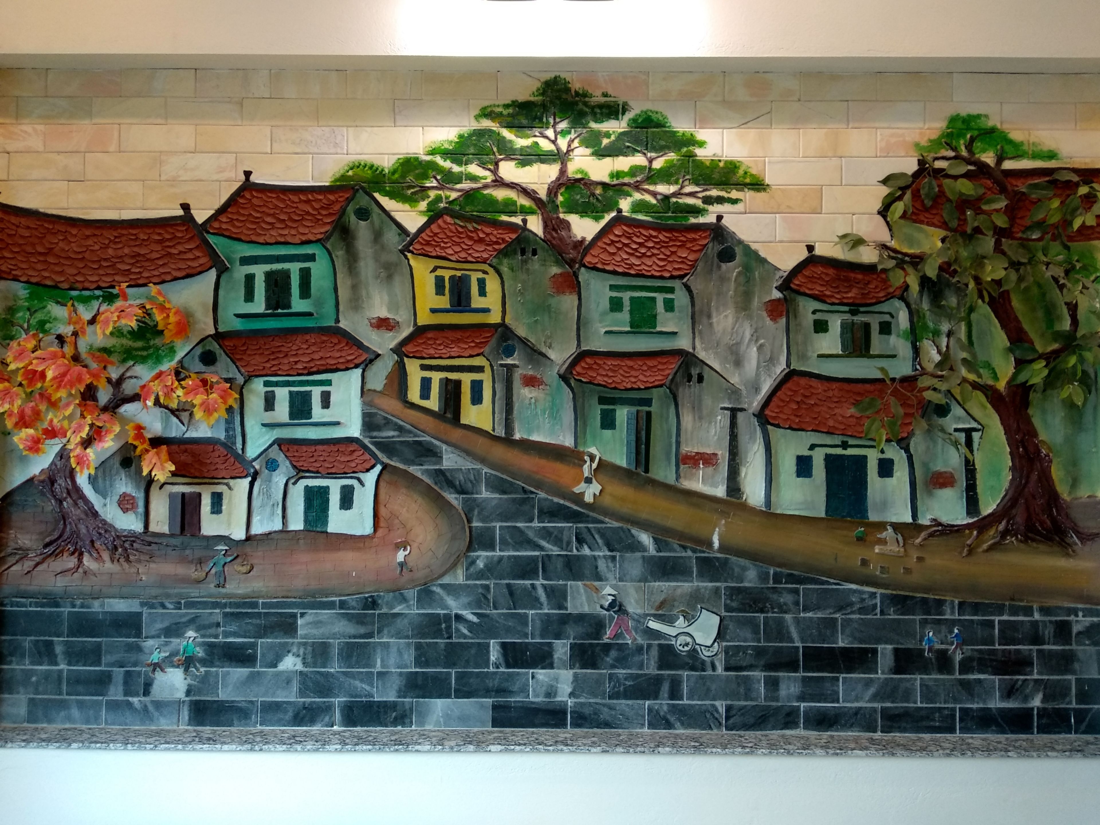 Un mural con casas, un árbol y personas en una escalera.