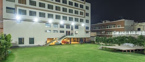 A modern hotel with a spacious courtyard, multiple floors, and a well-lit entrance.