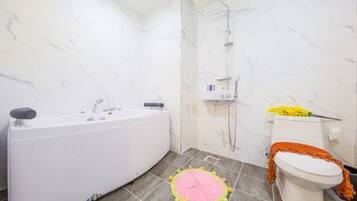 A bathroom with a bathtub, toilet, and shower.