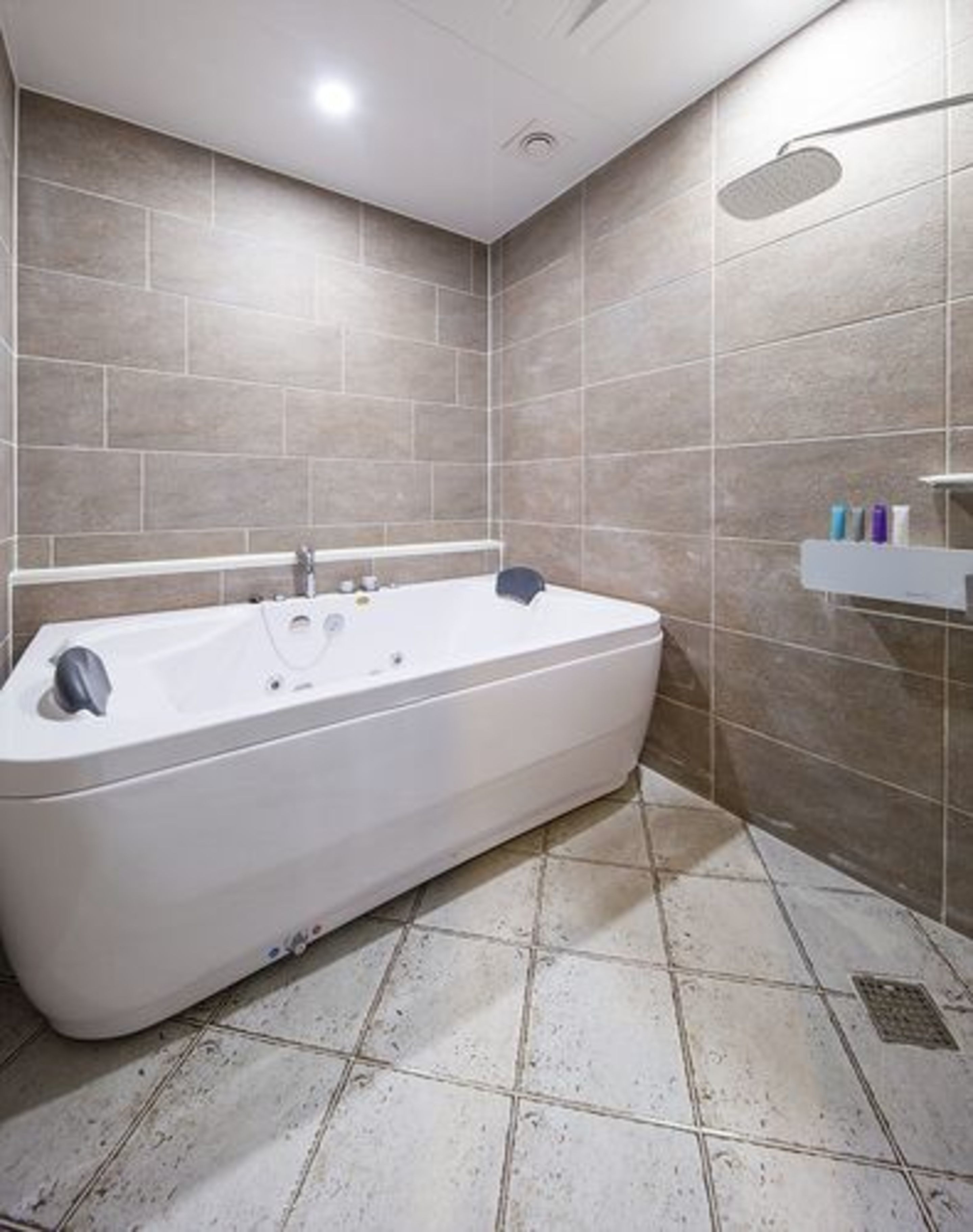 A modern bathroom with a freestanding bathtub, tiled walls, and a shower area.