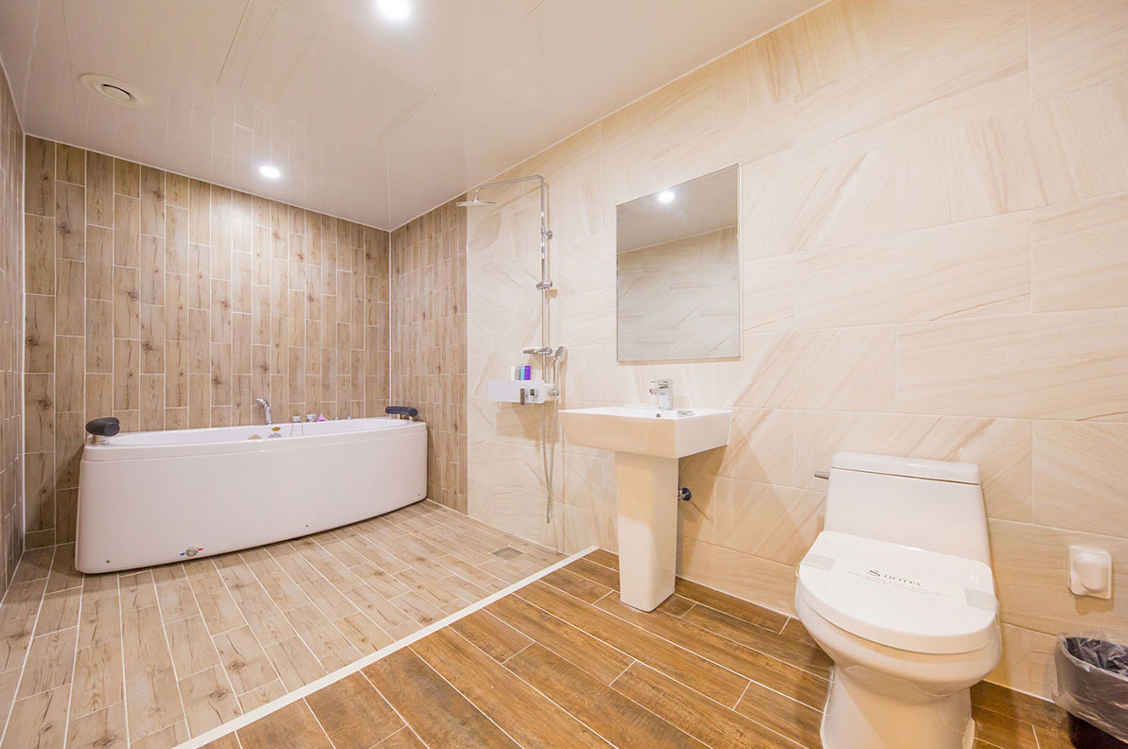 Ein modernes Badezimmer mit Badewanne, Waschbecken und Toilette.
