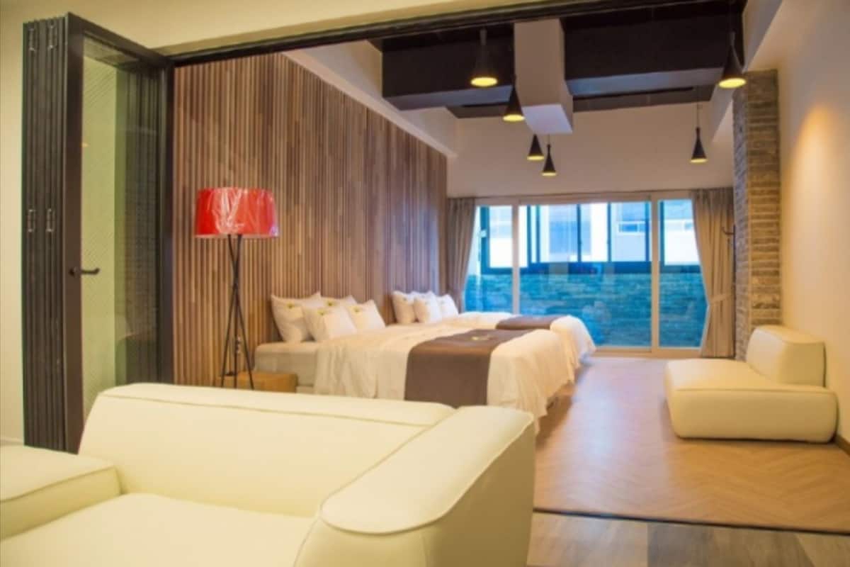 Ein modernes Hotelzimmer mit einem großen Bett, einer Couch und Meerblick.