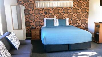 Un dormitorio con cama, cómoda, espejo y pared con diseño.