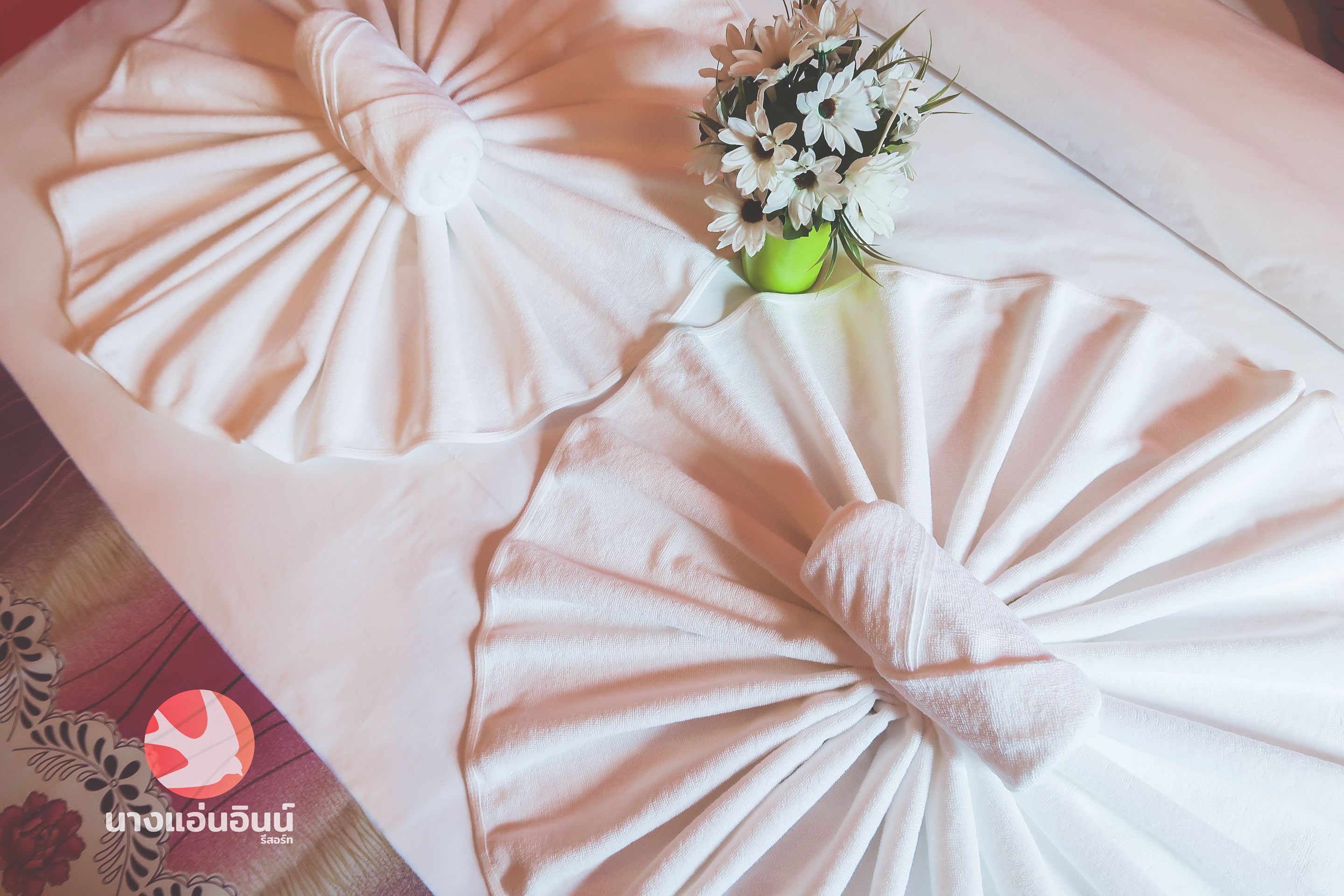 Una cama ordenada con un centro de mesa floral.