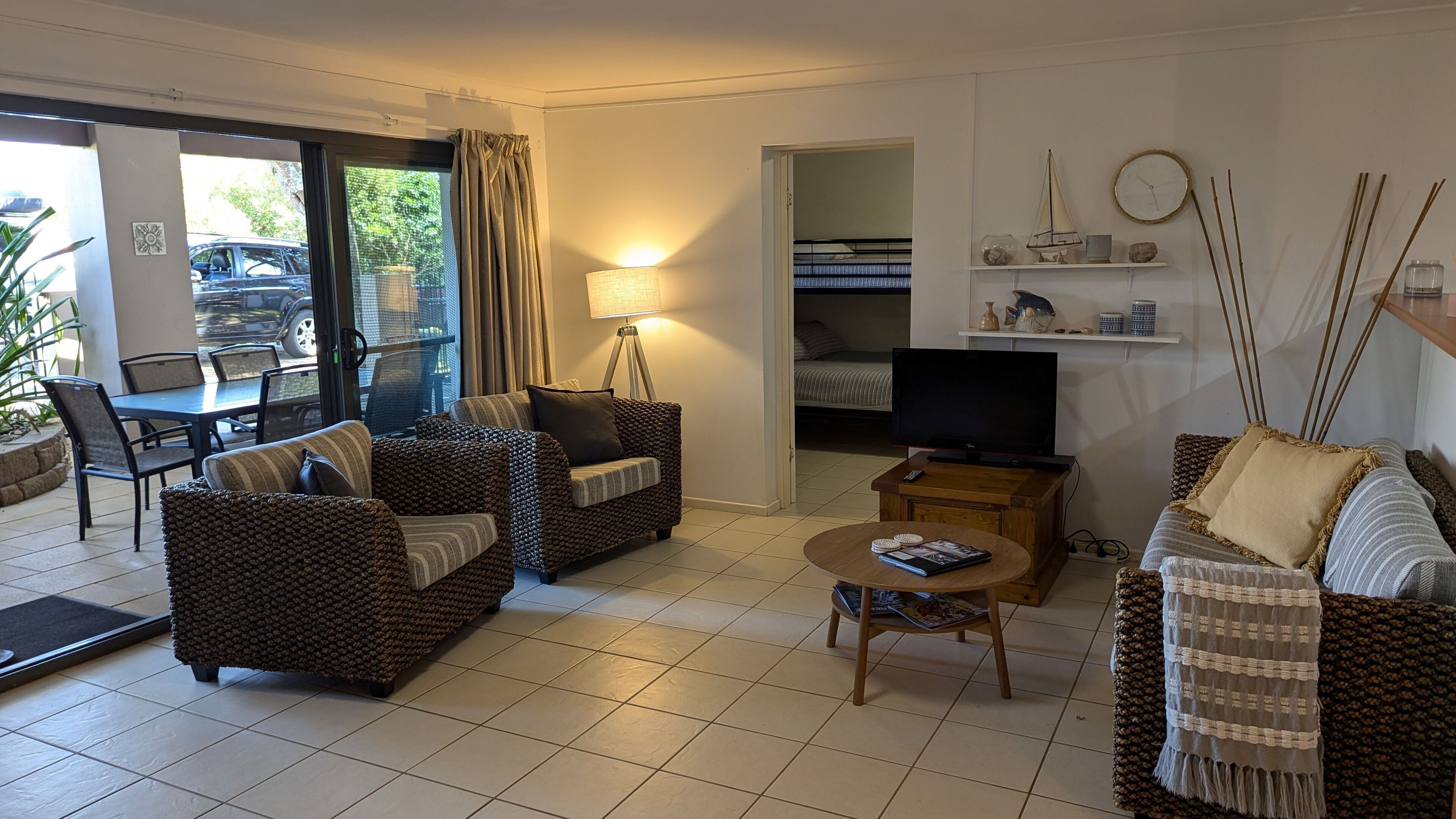 A living room with two sofas, a coffee table, a TV, and a dining area with chairs and a table.