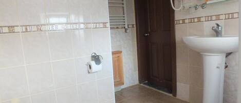 A bathroom with a toilet, sink, and a towel rack.