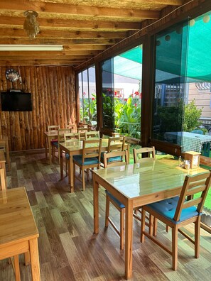 A restaurant with wooden furniture and large windows overlooking a garden. - Villa D'or Butik Otel (Sile)