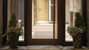 The entrance of Eden No. 7 with a modern design, featuring glass doors, wooden accents, and potted plants. - Hotel Eden No. 7 (Saas-Fee)