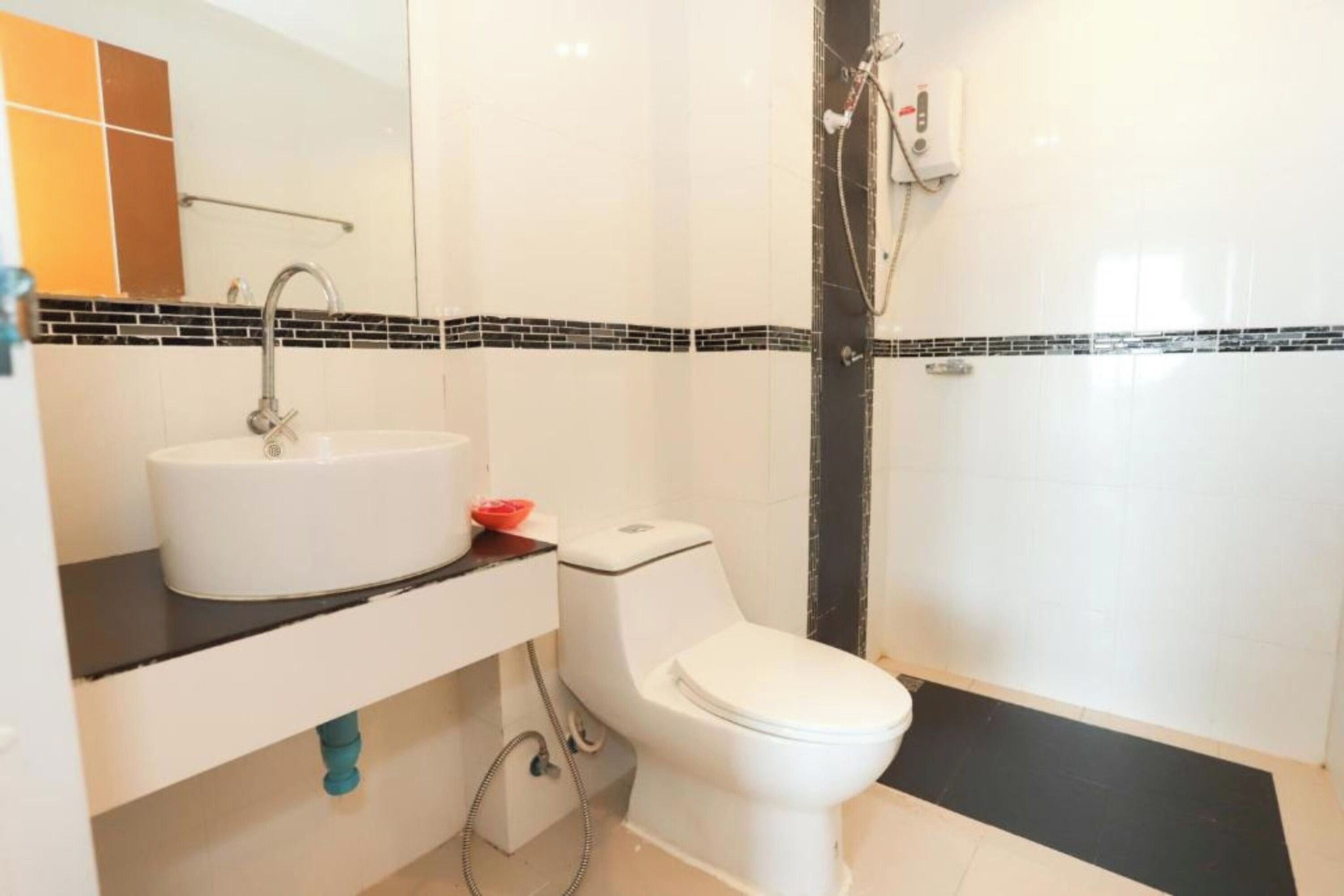 A bathroom with a white sink, a toilet, and a shower area.