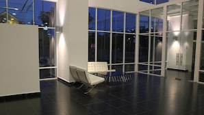 A modern lobby with a white sofa, a glass partition, and a view of the outside. - City Living with Panoramic Sea Views at Danga Bay (Johor Bahru)