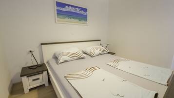 A bedroom with a bed, nightstand, and a wall-mounted painting.