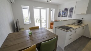 Une cuisine moderne dotée d’un plan de travail en granit, de meubles blancs et d’une cuisinière intégrée.