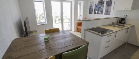 A modern kitchen with a granite countertop, white cabinets, and a built-in stove.