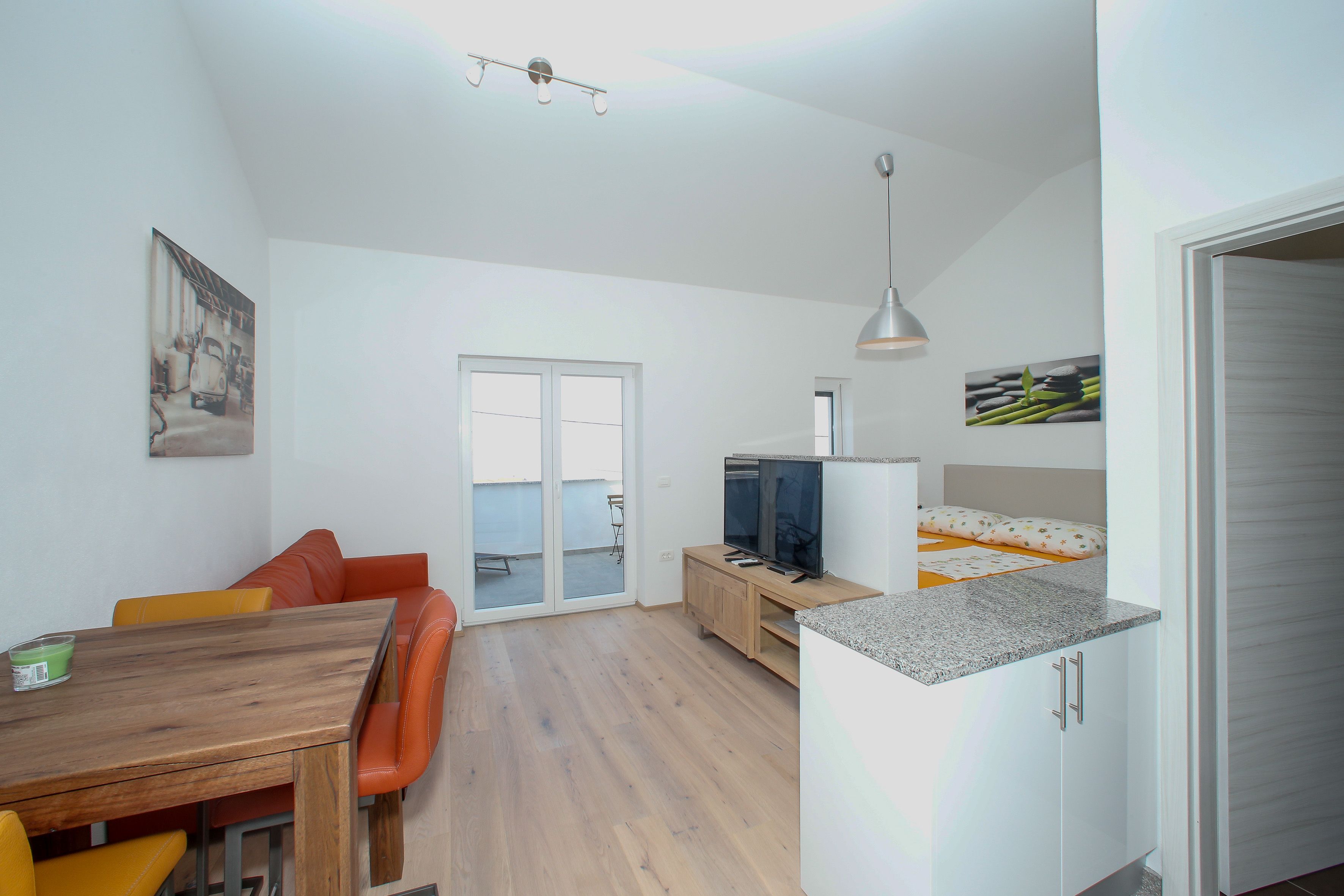 Apartamento moderno com área de refeições, cozinha e uma janela grande.