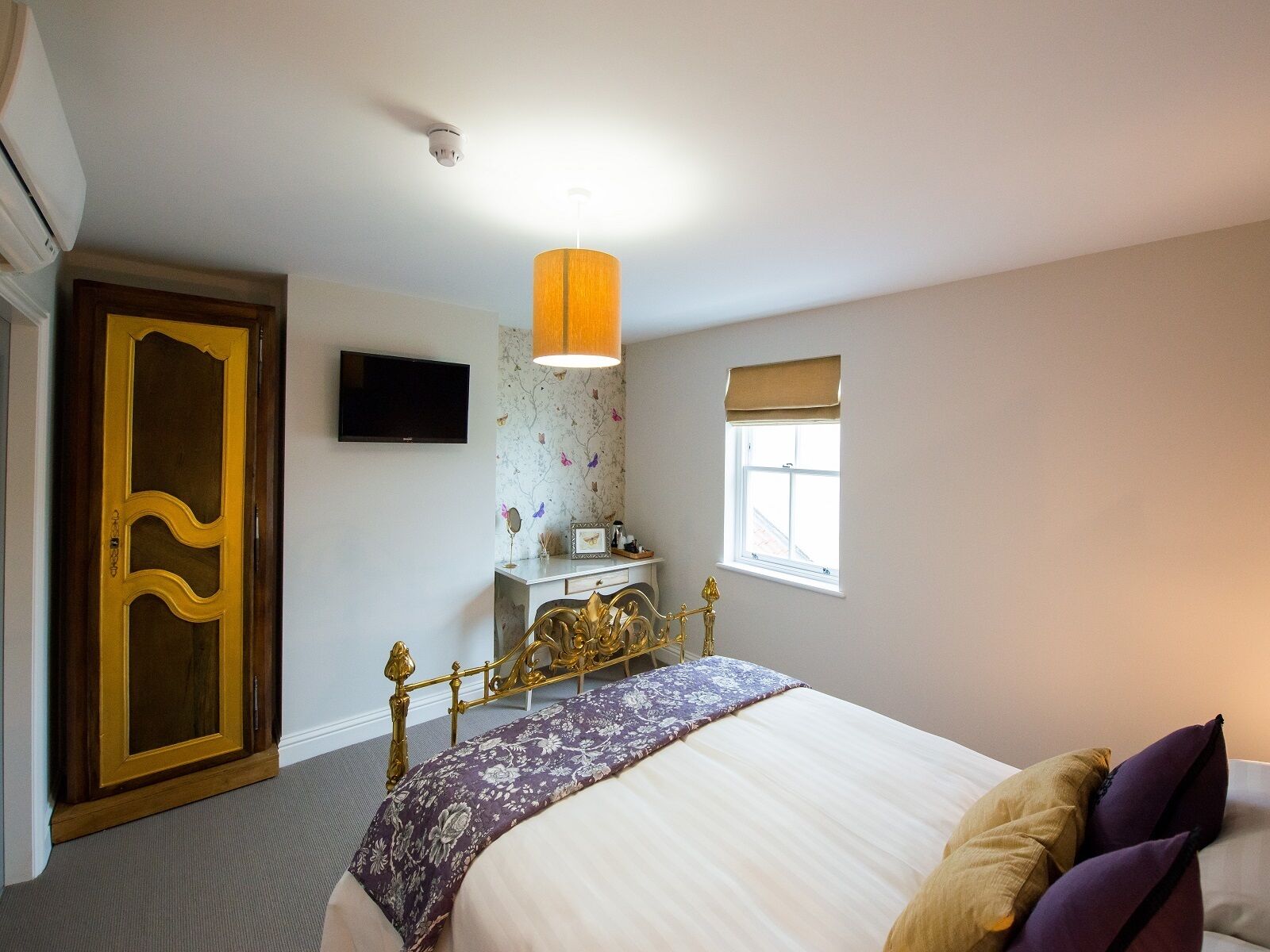 Une chambre à coucher comprenant un lit, un bureau, une chaise, une télévision, une fenêtre et une porte.
