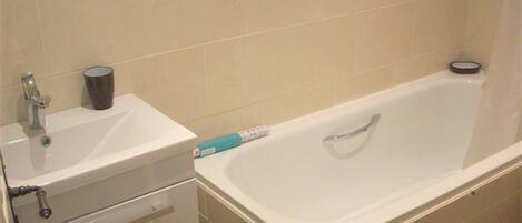 Une salle de bain avec un lavabo, un miroir et une baignoire.