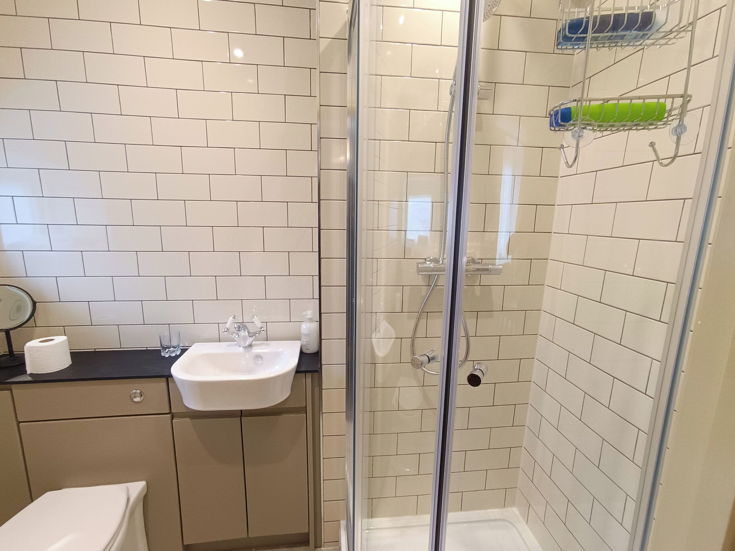 Een badkamer met een douchecabine, een wastafel en een toilet.