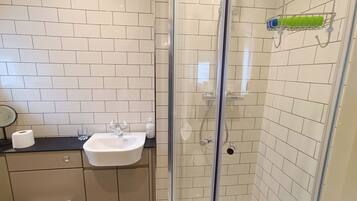 Een badkamer met een douchecabine, een wastafel en een toilet.