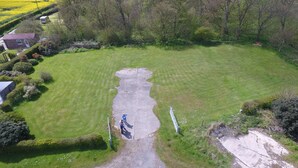 An aerial view of a grassy field with a concrete path leading to a gate. - Elm Tree Farm Bed & Breakfast (Withernsea)
