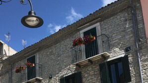 A stone building with a traditional facade, featuring a central entrance with an archway, two wooden doors, and a small window with shutters. - Art & Breakfast (Ripabottoni)