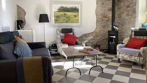 A cozy living room with a checkered floor, a fireplace, and a stone wall. - Art & Breakfast (Ripabottoni)