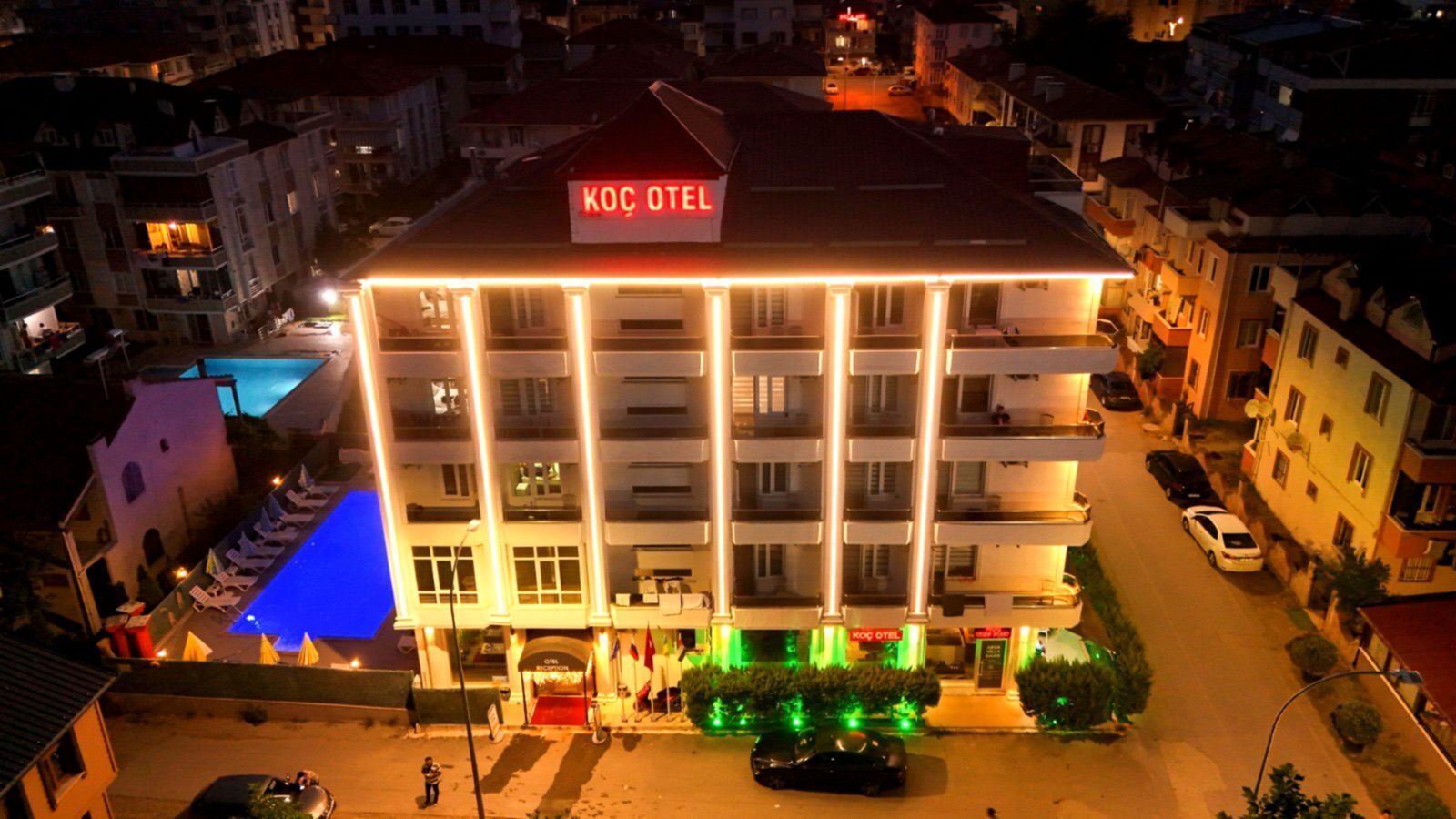 Ein mehrstöckiges Hotel mit Balkonen und einem Schwimmbad, mit dem Schild "KOC OTEL".