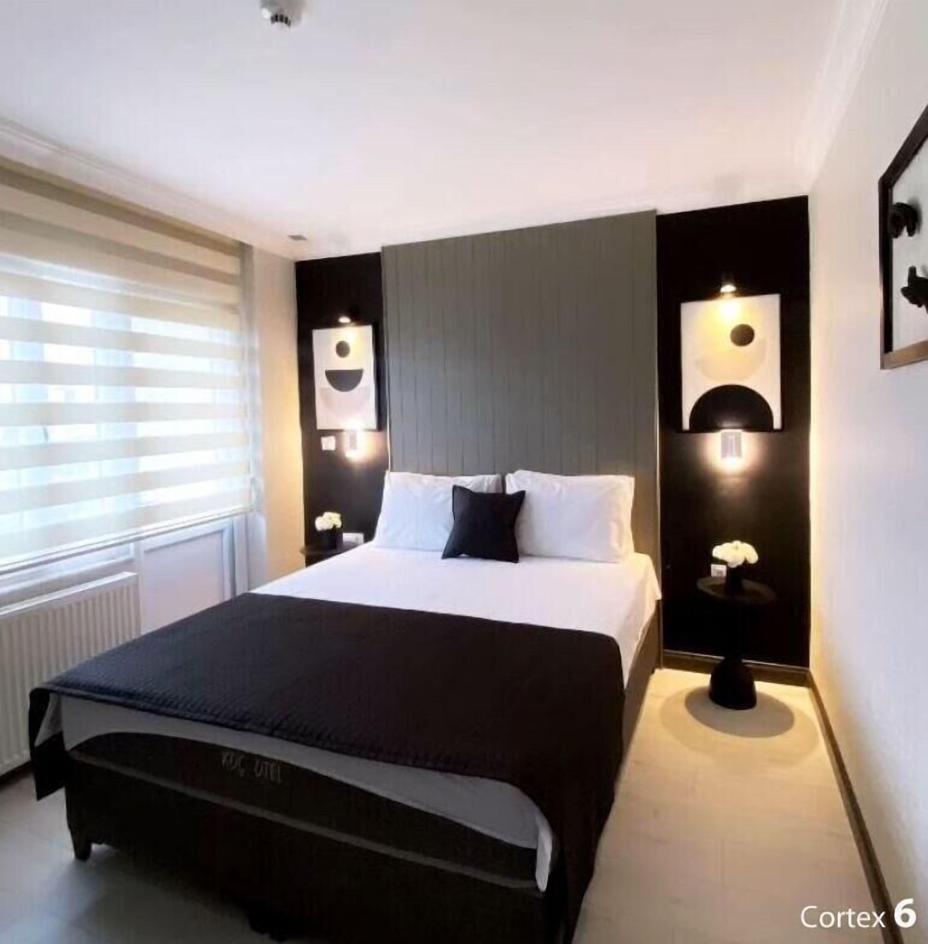 Ein modernes Schlafzimmer mit einem großen Bett, Nachttischen und Wandleuchten.