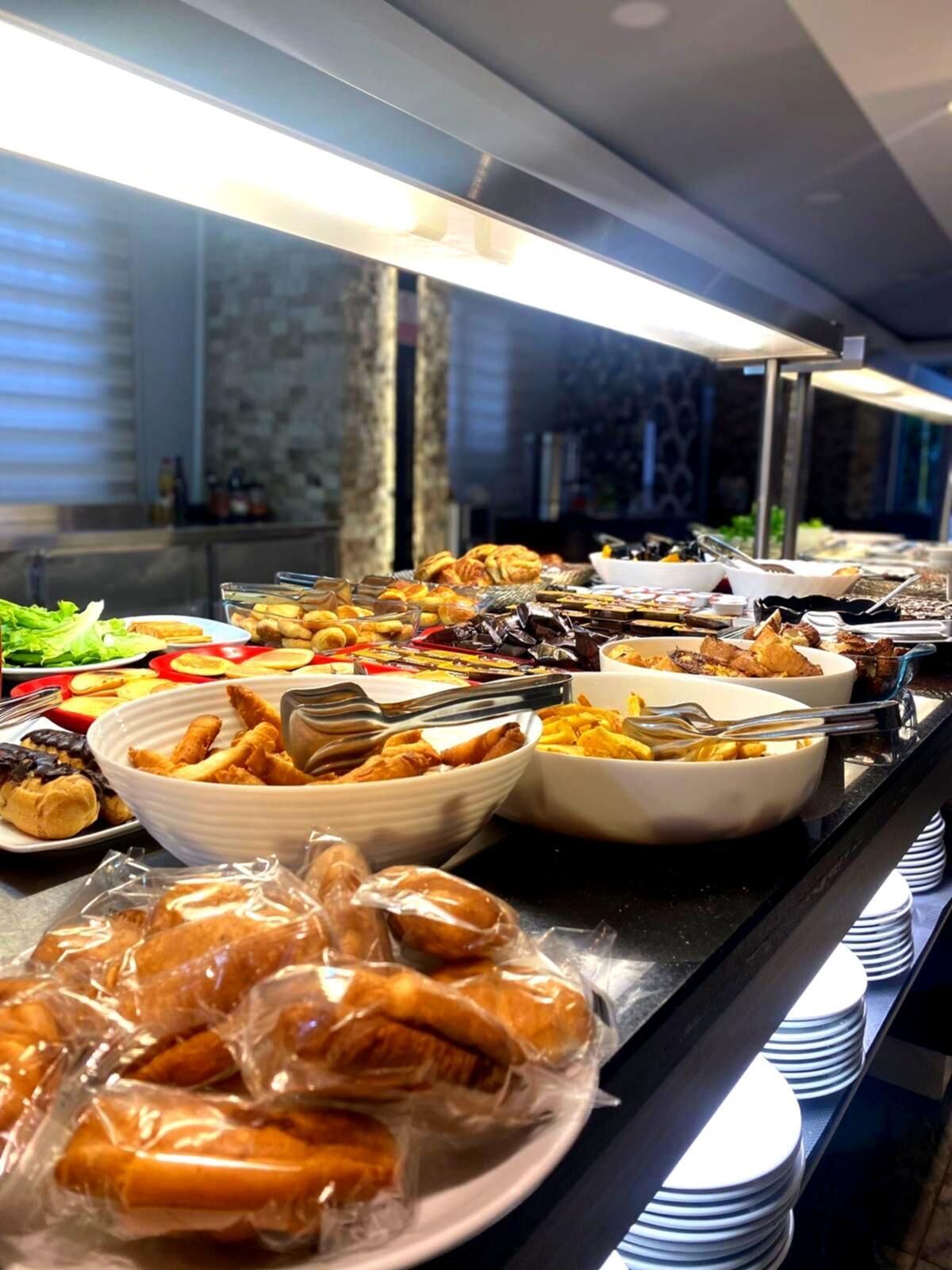 Un bufé con distintos alimentos, entre ellos pasteles, frutas y ensaladas.