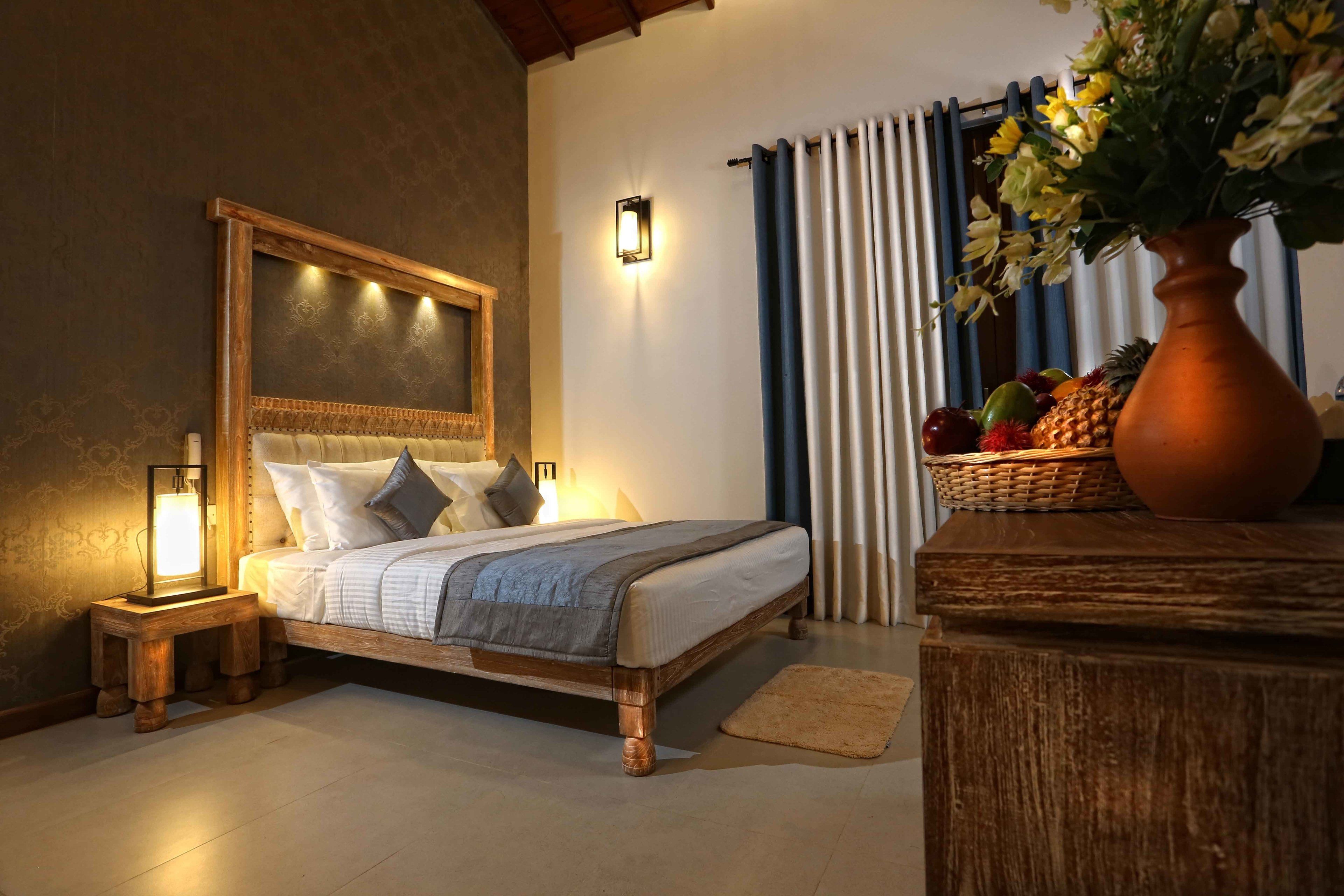 A bedroom with a wooden bed, bedside lamps, a nightstand, a vase with flowers, and a fruit basket.