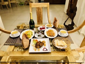 Savor a celebratory meal at this elegant dining table, complete with a variety of dishes and a chilled bottle of champagne.