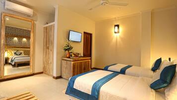 A hotel room with two beds, a wooden desk, a TV, and a mirror.