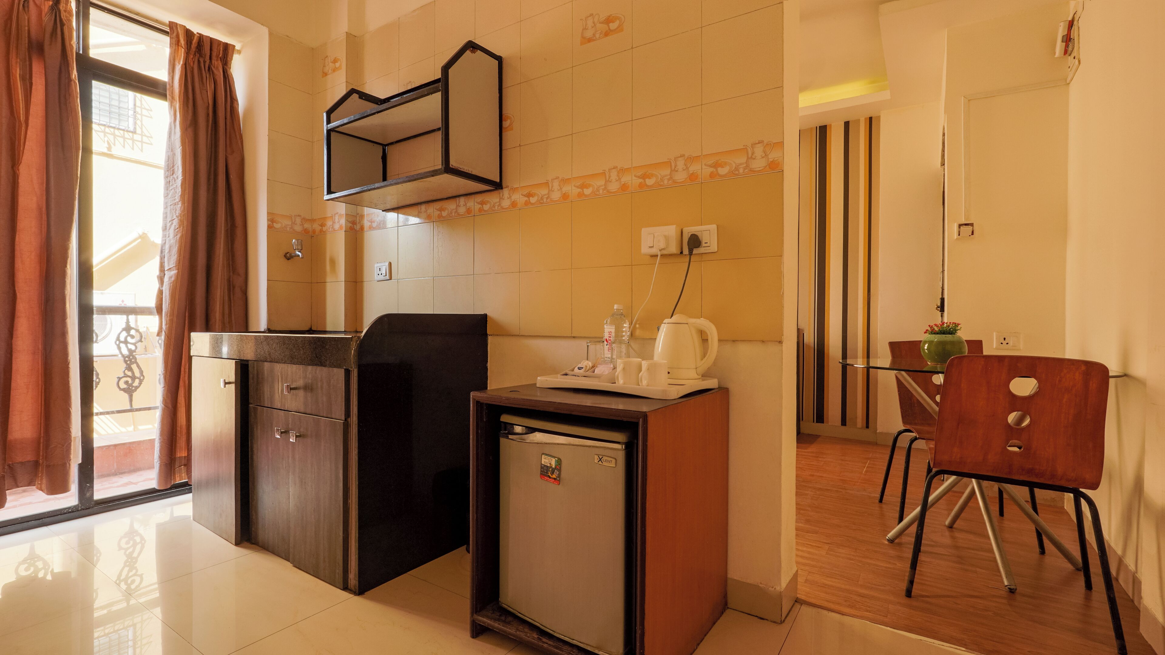 A compact kitchenette with a refrigerator, a microwave, and a small coffee maker.