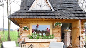 A wooden cabin with a sloped roof, a fireplace, and a seating area with two sofas and a table. - Villa Gorsky-Janso (Poronin)