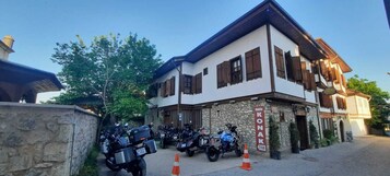 A building with a sign reading "KONAK" and several motorcycles parked in front.