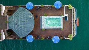 An aerial view of a boat with a swimming pool, outdoor seating, and umbrellas. - Rosa Boutique Cruise (Tuan Chau)