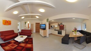A modern apartment with a living room, dining area, kitchen, and a small balcony. - Karglhof - Villa (Finkenstein am Faaker See)