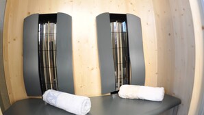 A sauna room with two seats and a table, wooden walls, and a thermometer on the wall. - Karglhof - Villa (Finkenstein am Faaker See)