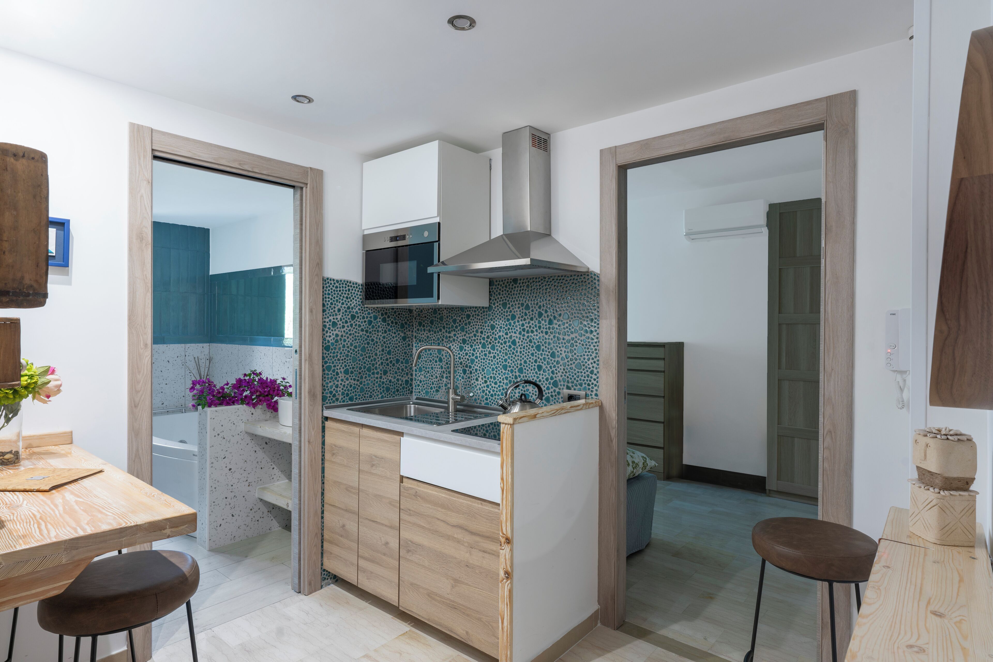 A compact kitchen with a microwave, stove, and modern sink.