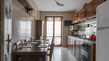 Une cuisine équipée d’une table à manger, de chaises, de placards, d’une cuisinière et d’un réfrigérateur.