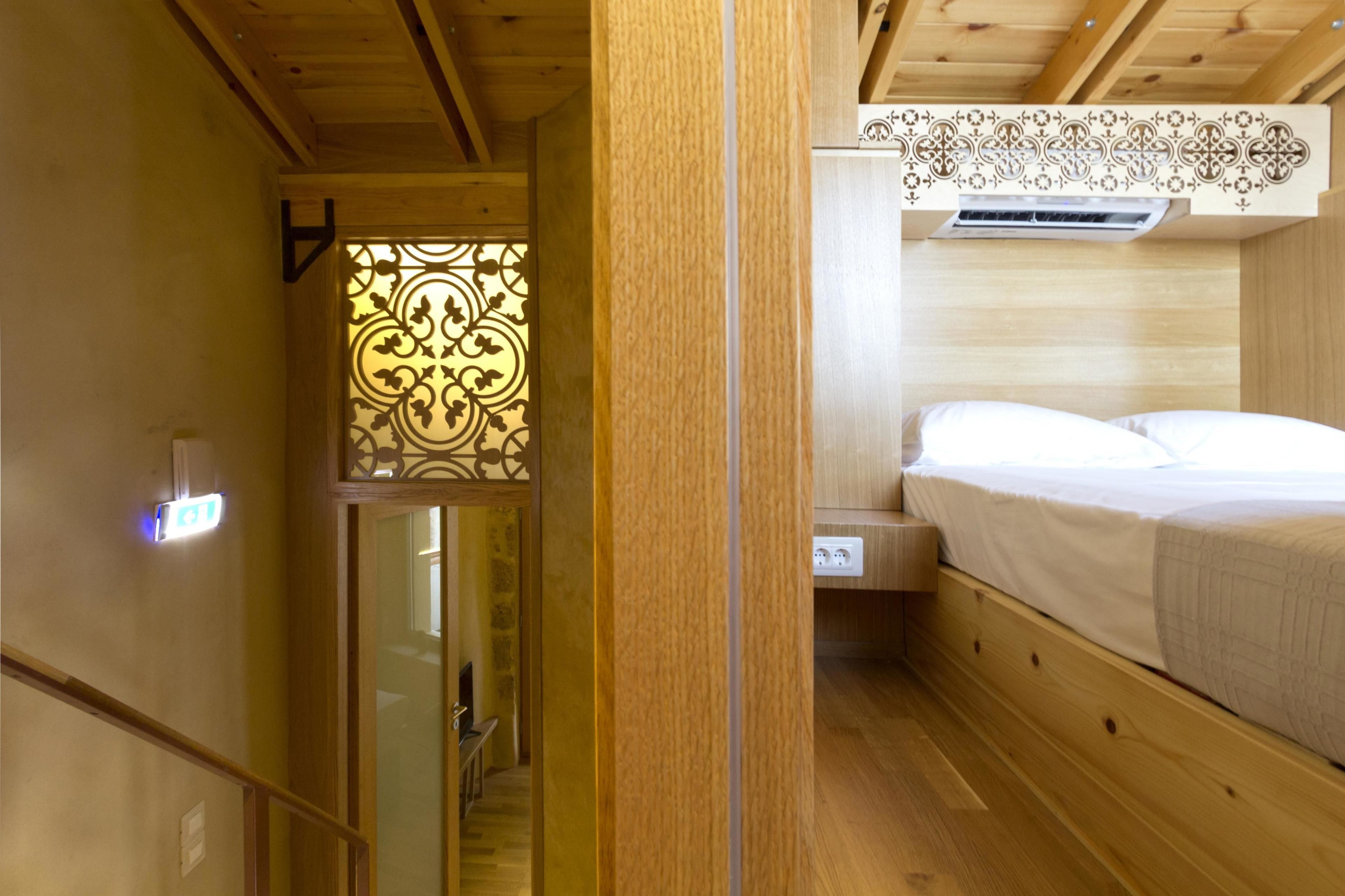 Un intérieur en bois comprenant un lit, un panneau décoratif mural et une prise électrique visible.
