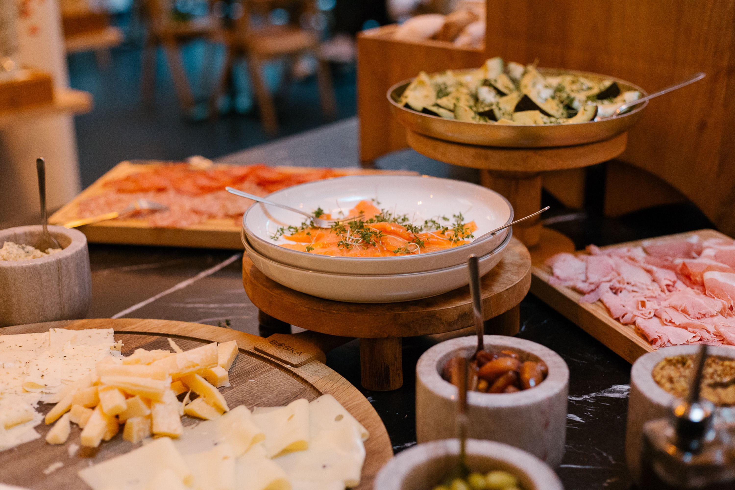 A buffet with various food items including cheese, smoked salmon, and salads.